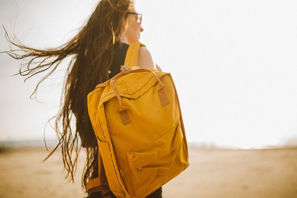 Rucksack junge Frau Haare Wind weht
