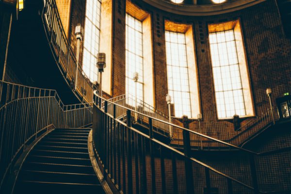 Empore mit Treppe in Vordergrund, Lichtschein durch große Fenster oben
