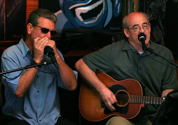 Baja Blues Boys spielen sitzend Mundharmonika und Gitarre vor Mikrofon