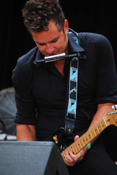 Dan Kelly spielt Mundharmonika und Gitarre Bühne