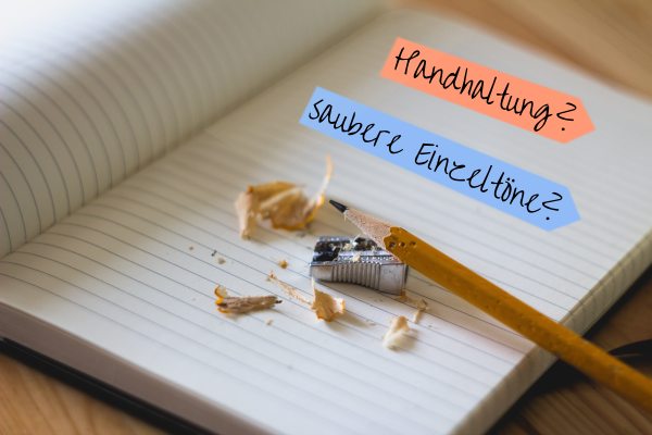 Notizbuch aufgeschlagen, darin geschrieben: Handhaltung? saubere Einzeltöne?